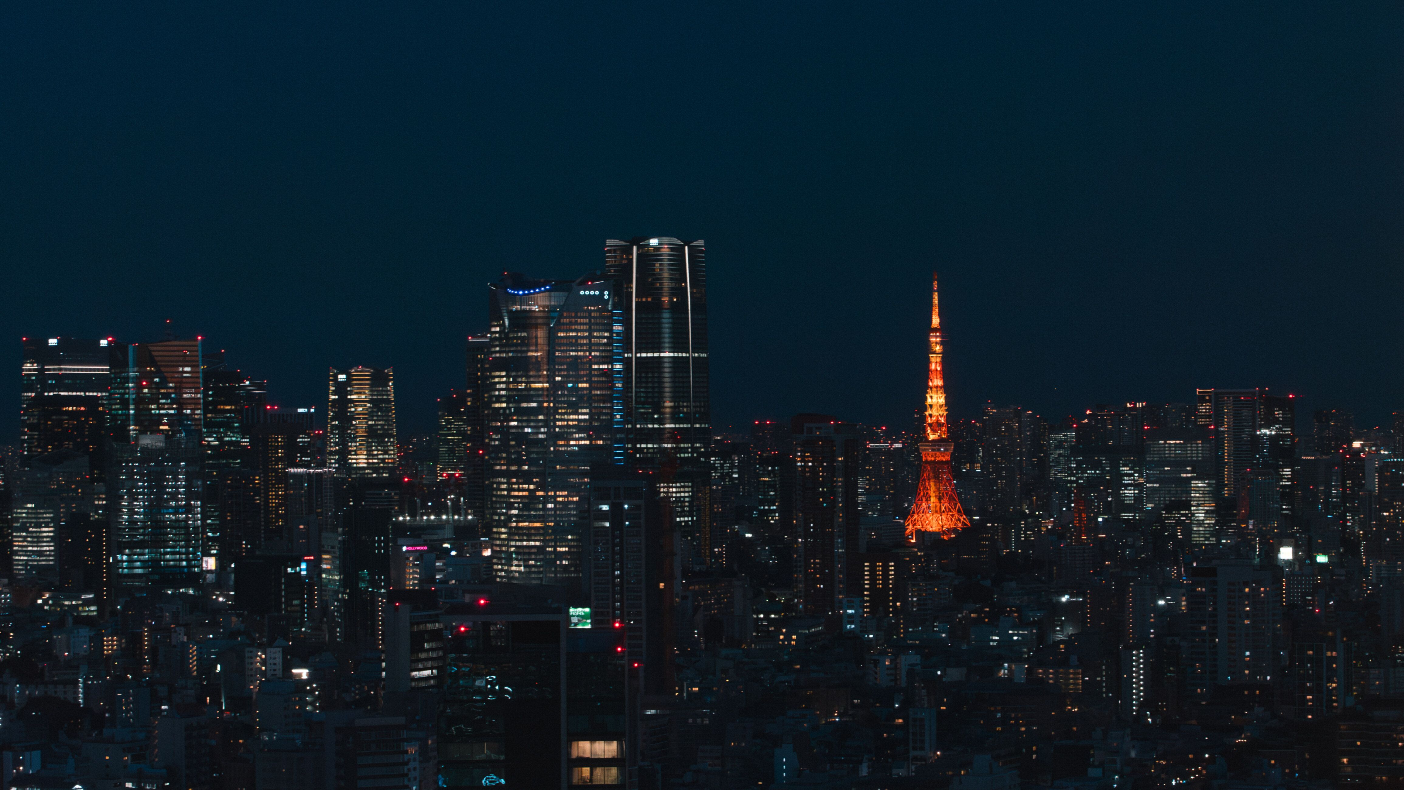 The towers of Roppongi at night, with Tokyo Tower lit beyond them